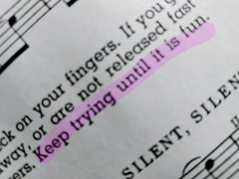 Photo of some text and sheet music. The image is at a Dutch angle, for dramatic flair. The important part of the text is highlighted in a light purple or pink. It reads: "Keep trying until it is fun."