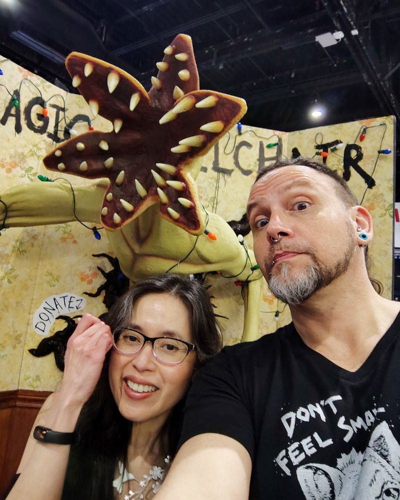 Photo of two people in front of a Demogorgon statue.