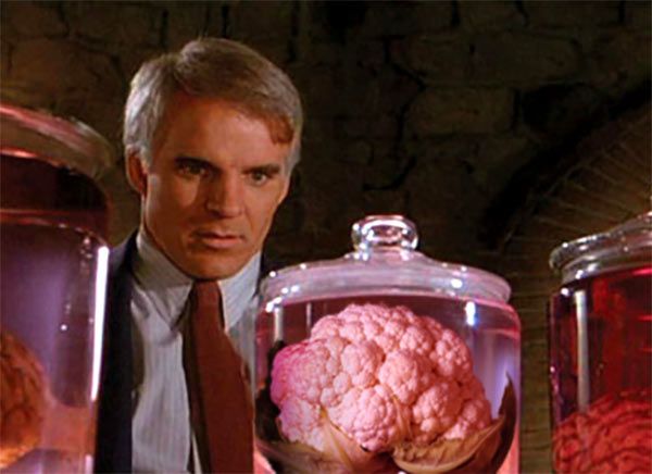 Steve Martin looking at a cabbage in a jar. 