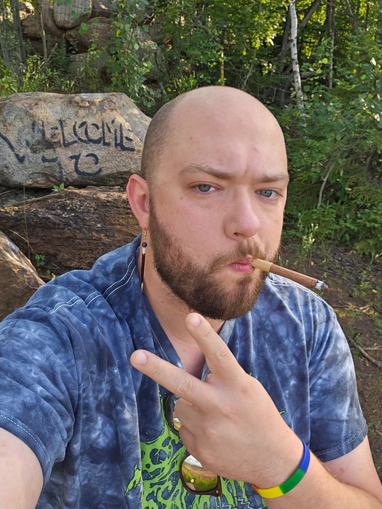 Selfie in a long abandoned campsite, sucking a swisher sweet and giving a peace sign. In my cattle Decapitation tie dye shirt and porcupine earrings (the irony isn't lost on me)