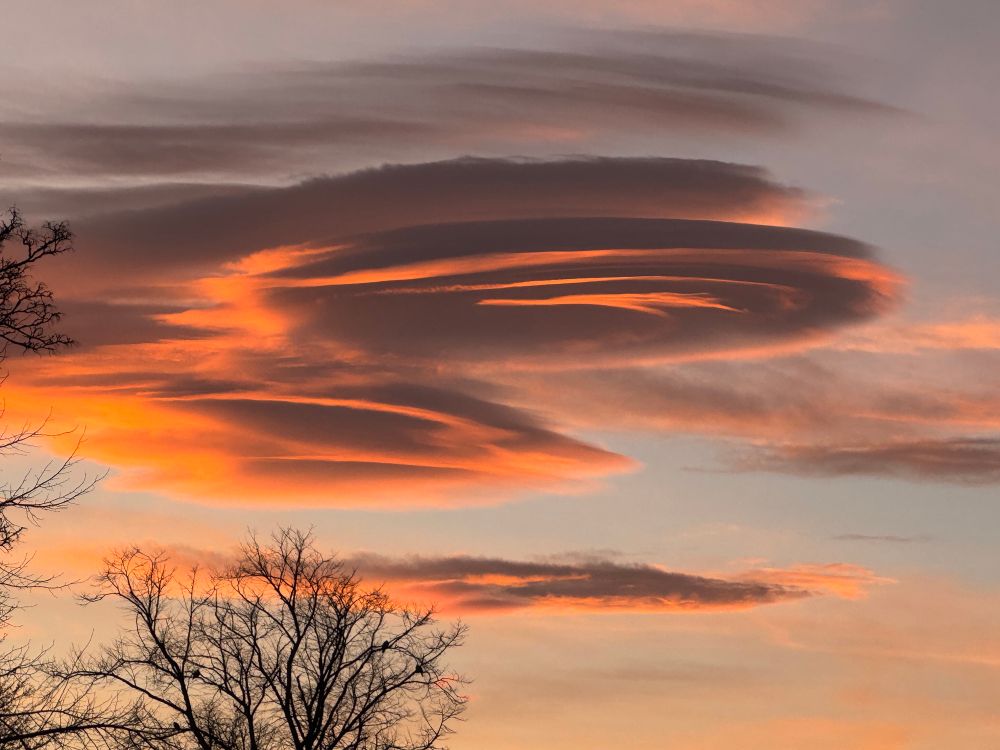 Morning sky with pink-tinged circular cloud formation. 