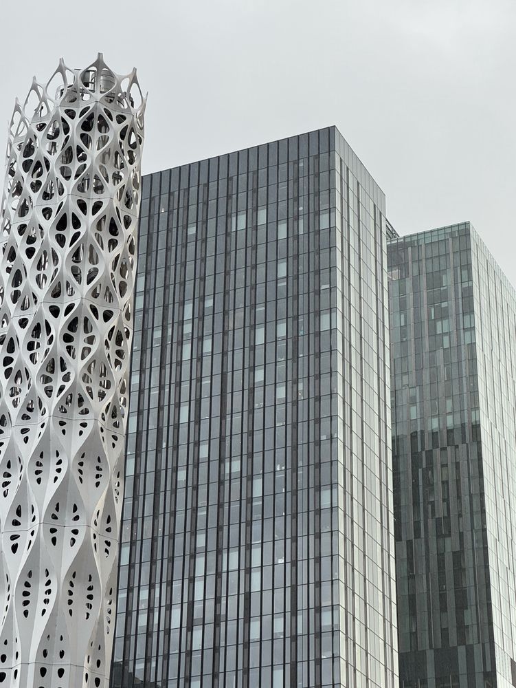 Glassy tower blocks reflecting a grey Manchester sky. 
