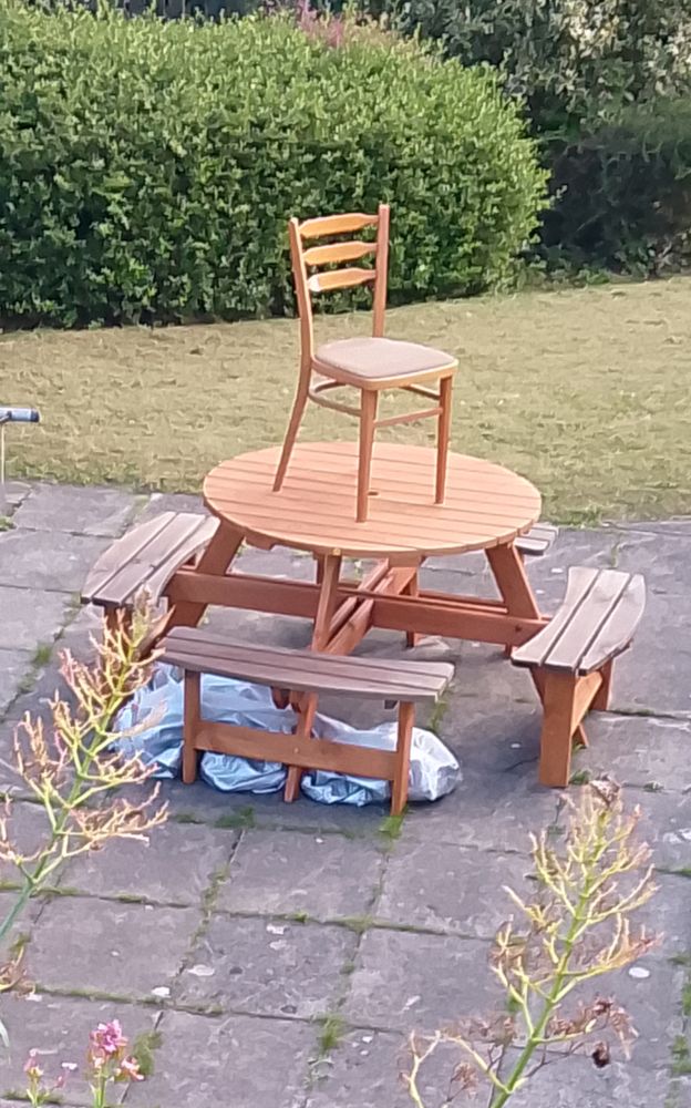 A chair on top of a table, with three benches around it 