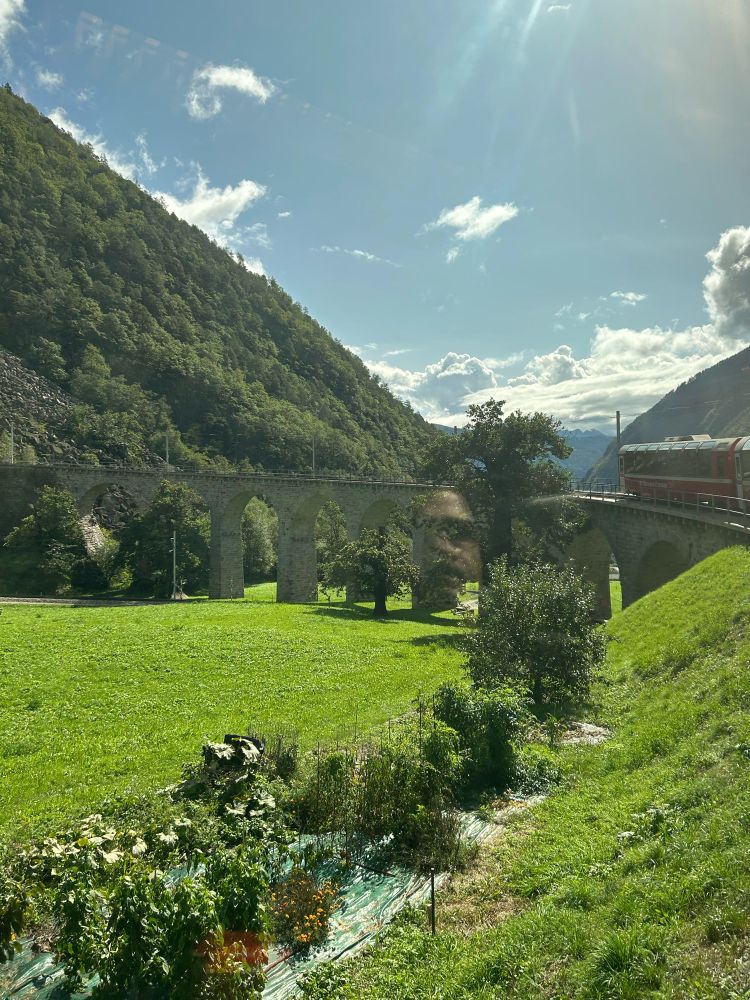 Vista of the Italian countryside with mountains and a train bridge