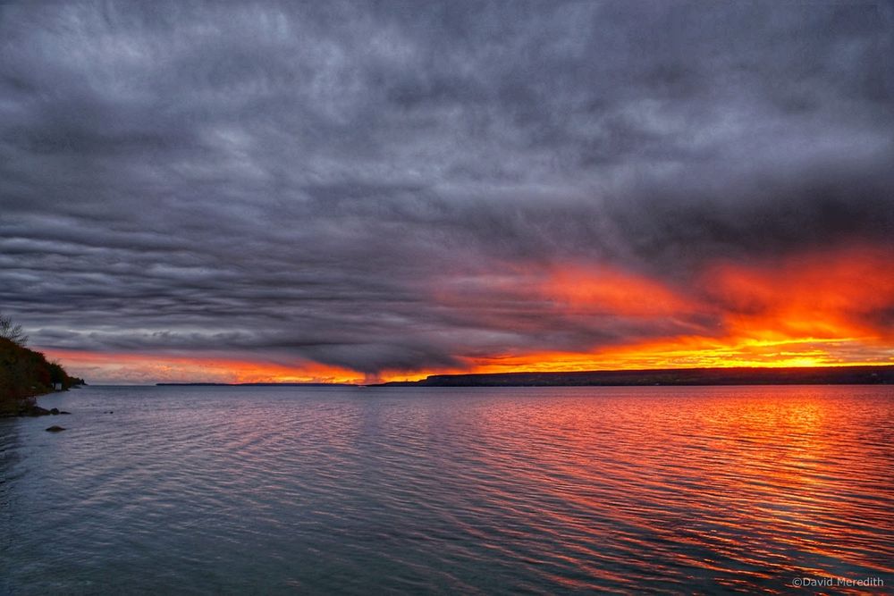 Storm clouds over Colpoy's Bay, Ontario, shortly before sunrise. Some of the clouds are glowing red from the rising sun.