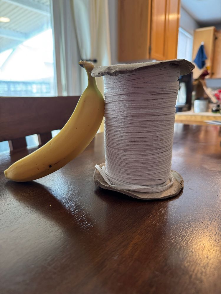 A spool with about 90yrds of thin white elastic. It is about the height of a banana, banana included for scale. 