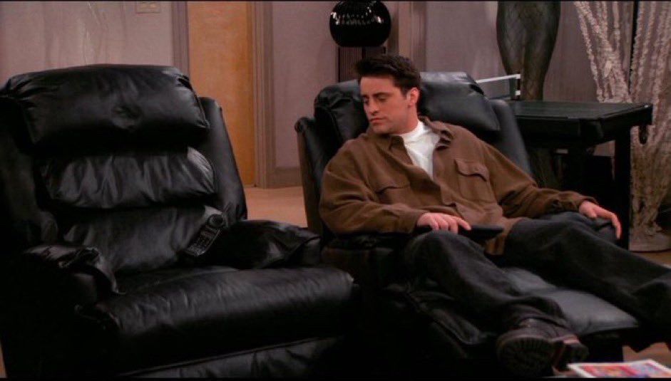 Scène de la série Friend où le personnage de Joey est dans un fauteuil et regarde le fauteuil vide à côté de lui.