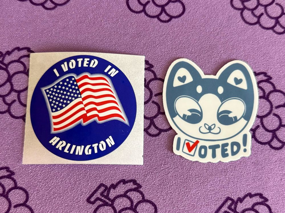 two stickers, one “I voted in Arlington” with an American flag, the other a cute “I voted” with a cat