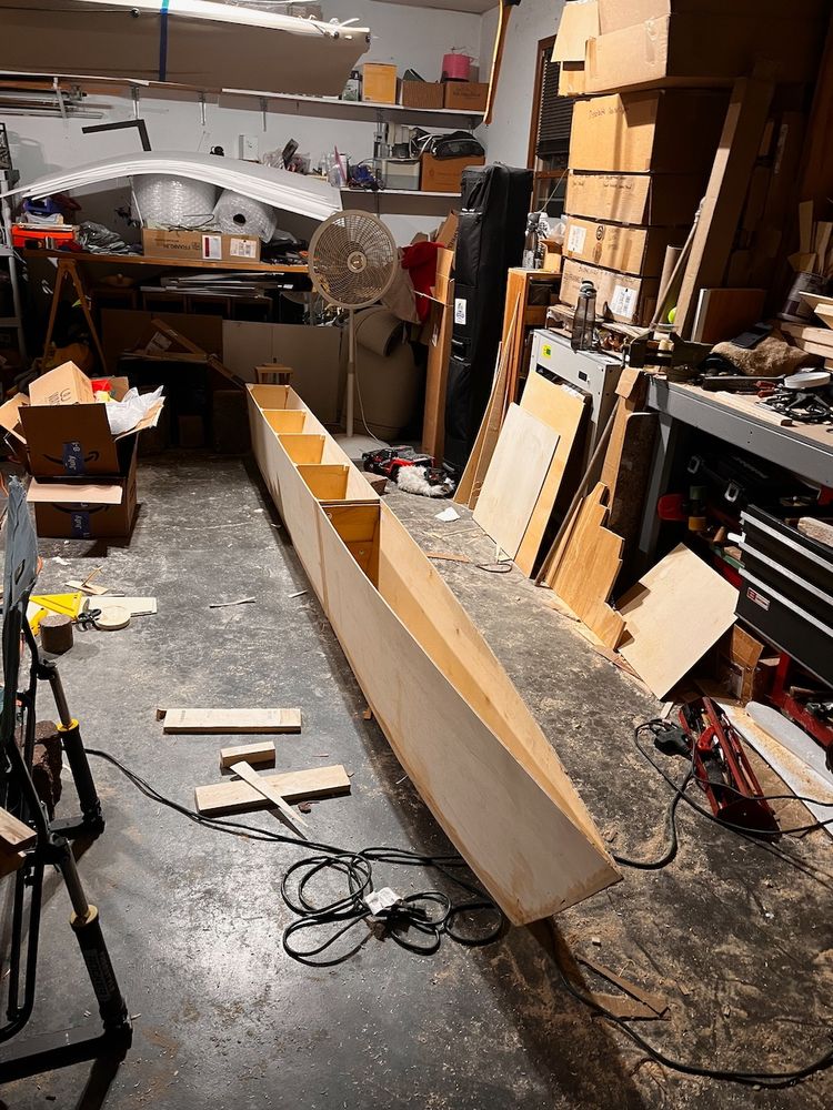 A partially built catamaran hull, viewed from the top and front.