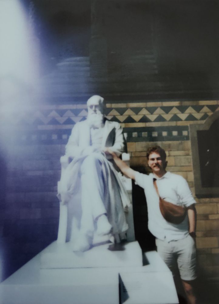A picture of me with my hand on a statue of Darwin, taken at the Natural History Museum in London. I look far happier about it than he does.