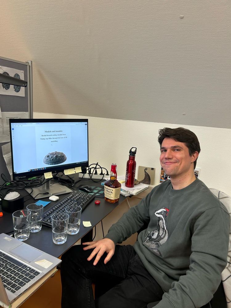 One happy boy sitting in front of his completed thesis on a computer screen.