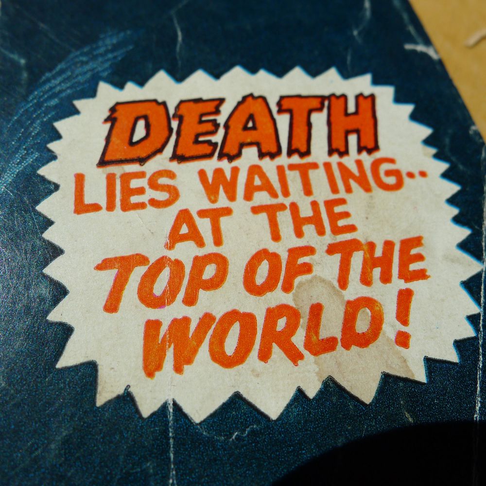 Text reading DEATH LIES WAITING--- AT THE TOP OF THE WORLD! in a jagged word balloon.
