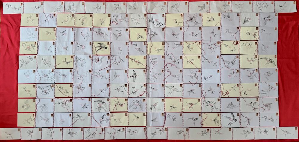 a blanket consisting of 140 envelopes stitched together. each envelope has pen drawings of swallows on the surface, and each envelope is stamped with harsh bible verses