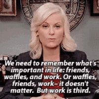 Leslie Knope from the TV show Parks and Recreation saying, "We need to remember what's important in life: friends, waffles, and work. Or waffles, friends, work - it doesn't matter. But work is third."