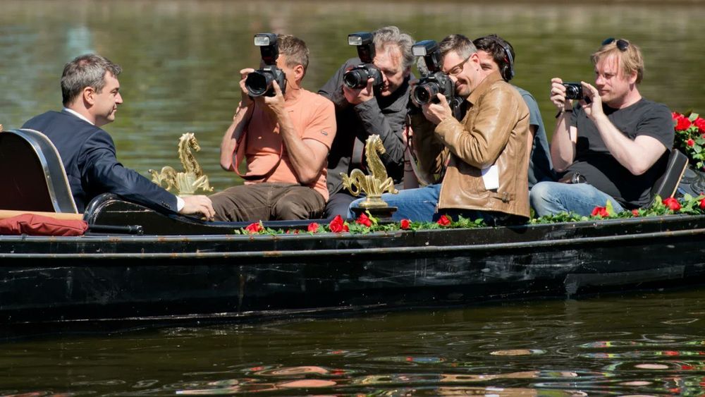 Markus Söder mit nicht weniger als 5 Fotografen im engen Ruderboot, und dem selbstgefälligsten Grinsen im Gesicht das man sich vorstellen kann.