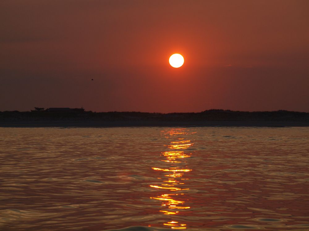 A path of golden orange leads to the setting sun over Barnegat Bay. Long Beach Island, New Jersey. 