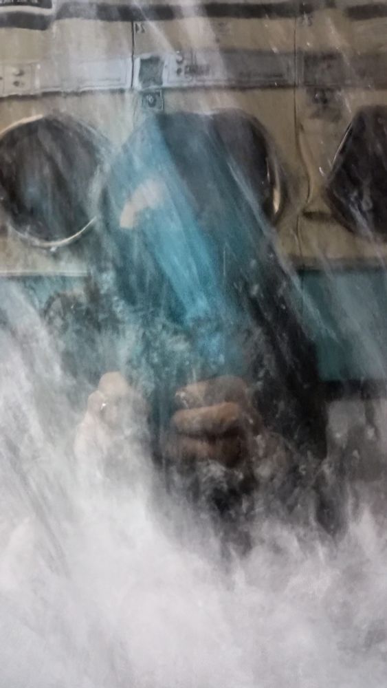 Reflection of me in front of laundromat machines. Water from the machine adds a blurry effect.