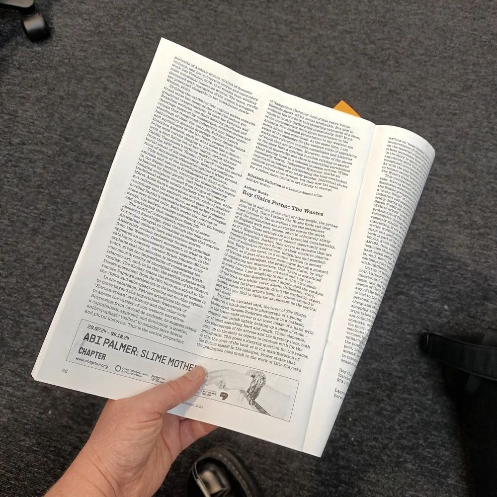 my hand holding September's issue of Art Monthly open to the page with my review