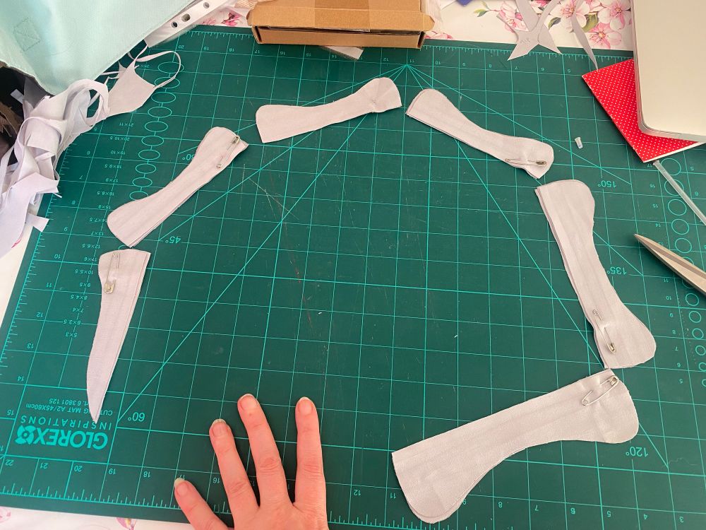 Light blue-gray cloth cut into roughly bone shapes arranged in a circle