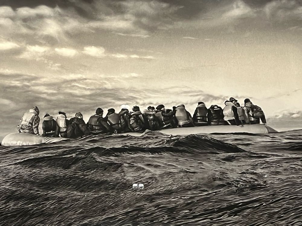 Kultegning (ligner fotografi) af flygtninge i gummibåd på oprørt hav af Robert Longo.