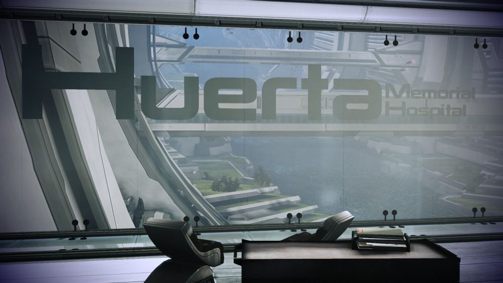 A screencap from the game Mass Effect 3, showing a table and two chairs in front of a window. On the window it says, "Huerta Memorial Hospital".
