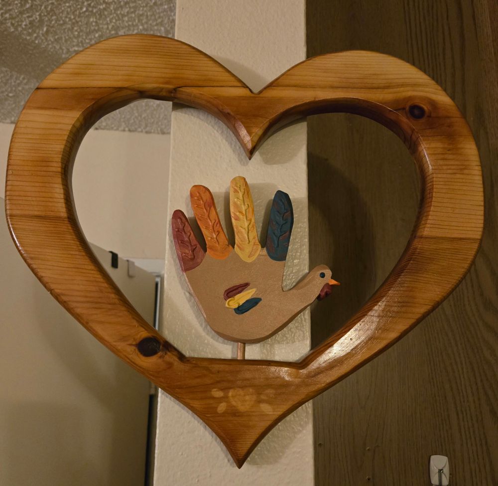 Decorative heart with removable seasonal decoration of a hand turkey. 