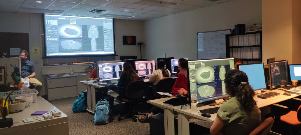 The computer lab at UTCT, with large monitors showing CT data being processed by students. Dave Edey sits at a PC at the front of the room, demonstrating how to use the Dragonfly CT processing software. 