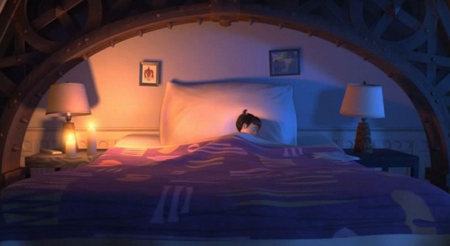 Still from Monster’s Inc of Boo looking tiny while sleeping in Sully’s giant bed