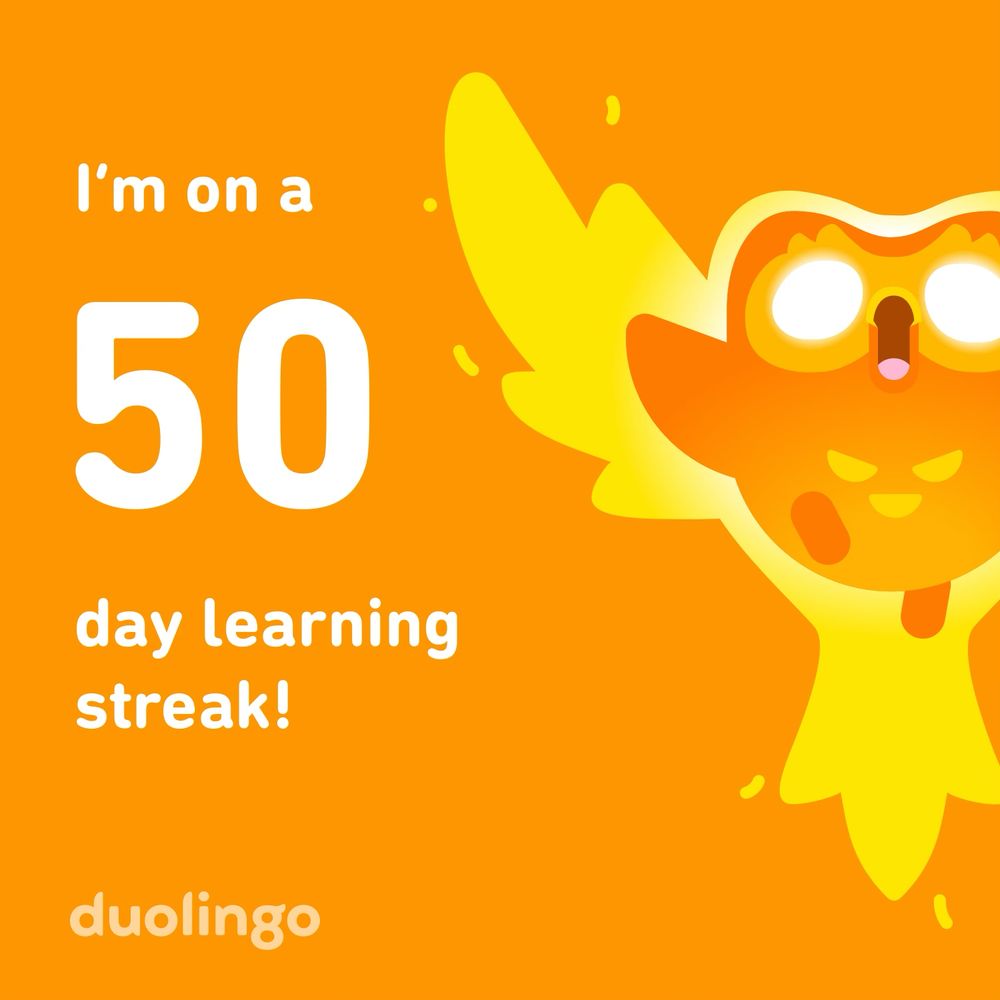50 day learning streak. Duolingo is a green owl, but in this photo, they’re orange, powerful and glowing yellow, with big white pupil-less eyes, celebrating my success.   