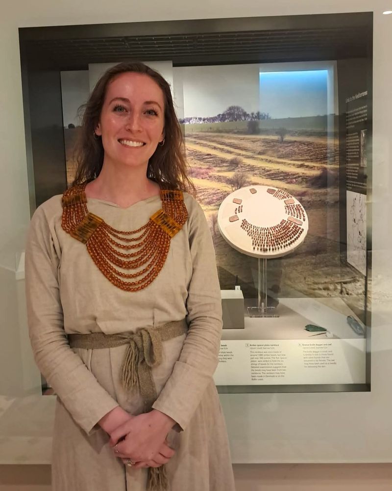 Caitlin, woman with brown mid length hair wearing replica necklace in front of Amber necklace
