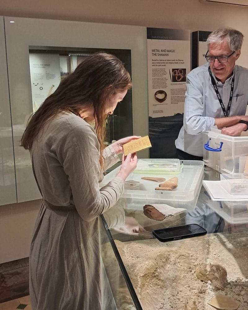 Woman looking at bronze age replicas whilst director looks on