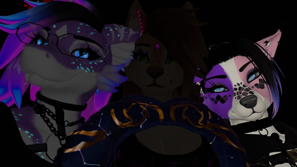 A close-up of three colorful anthropomorphic avatars posing side by side in a dark environment.

The left avatar has a dragon-like face with bright blue eyes, purple-and-blue hair, glowing blue spots, glasses, and a black choker with chains.

The middle avatar resembles a canine with brown fur, green eyes, long brown hair, and small pink heart decorations near one ear, wearing a dark blue garment with gold accents.

The right avatar is a dog-like figure with white, purple, and black facial markings, blue eyes, and black hair swept to one side, wearing a black outfit with straps.