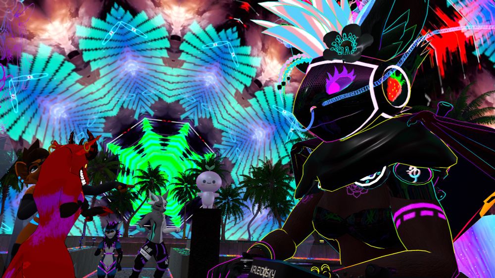 A photo taken in VRChat shows a protogen Strawberry on the decks at Kaleidosky. Furries dance in the background. Palm trees contrast with the bright, geometric patterns in the sky.