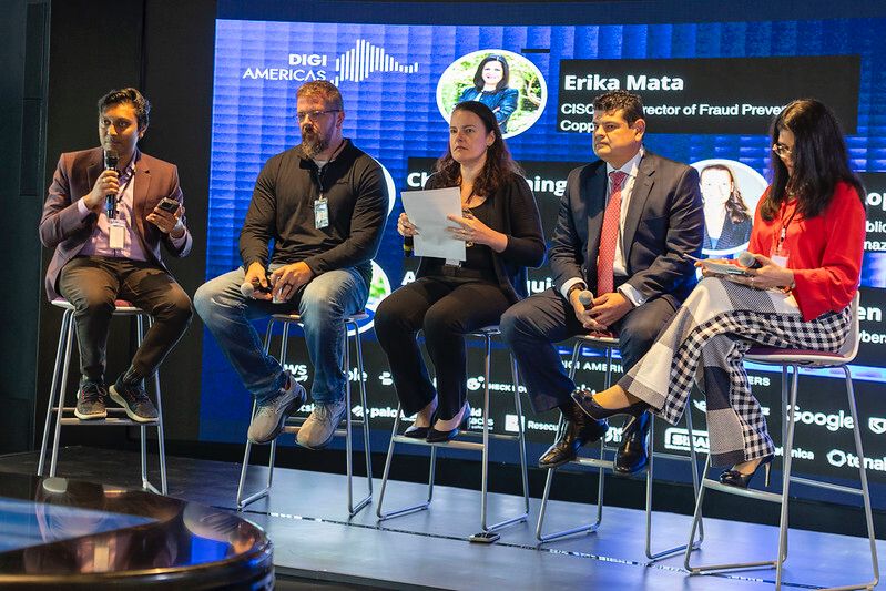 A photo of Yameen Huq and fellow panelists on stage at the conference.