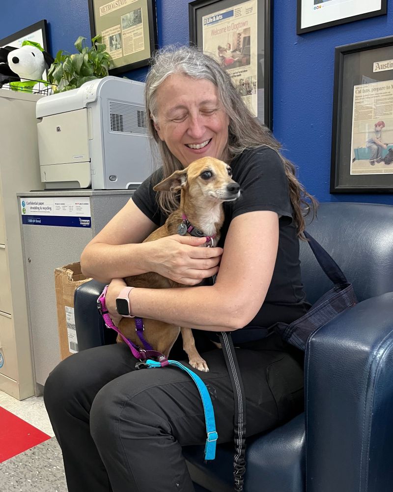 The chichi smirks as she is embraced by her loving forever human in a lobby area.
