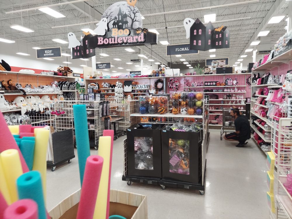 A halloween display in a Michael's crafts store labeled "boo boulevard." On the left, the aisles are traditional Orange and Black, while the right is pink and glittery.