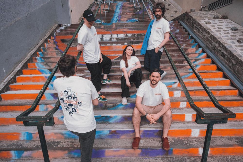 L'équipe fondatrice d'Origami qui prend la pose dans un escalier, habillé du nouveau t-shirt Origami - saison 2 et de la casquette.