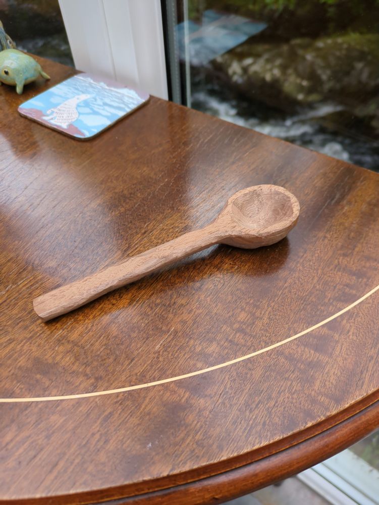 A close up photo of a wooden spoon on a wooden table