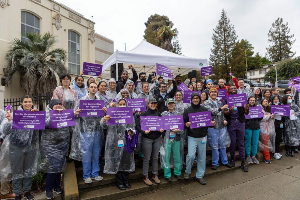 Group photo of members of the AHS residency programs standing outside in the rain at the unity break