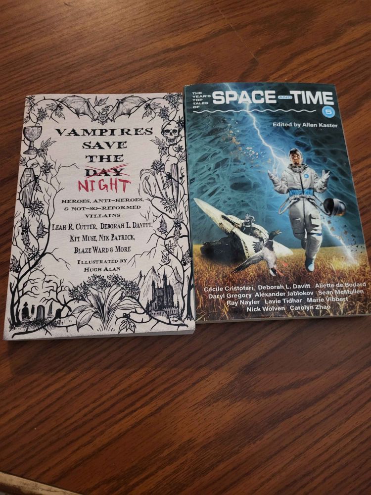 Two books, side by side: Vampires Save The Day/Night and The Year's Top Tales of Space and Time.