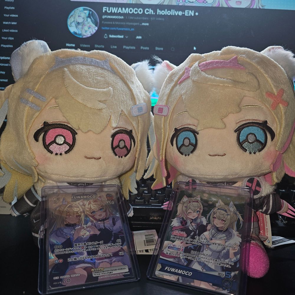fuwamoco plushies with hololive ocg cards on them