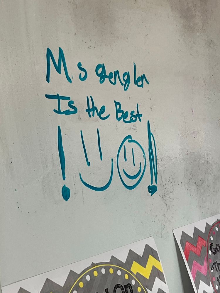 A note on the whiteboard which reads “Ms Gengler is the best!” with smiley faces. 