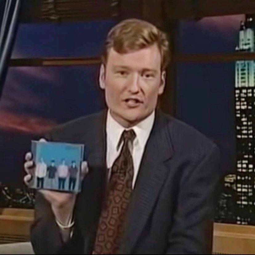 Conan O’brien holding a Weezer Blue Album CD
