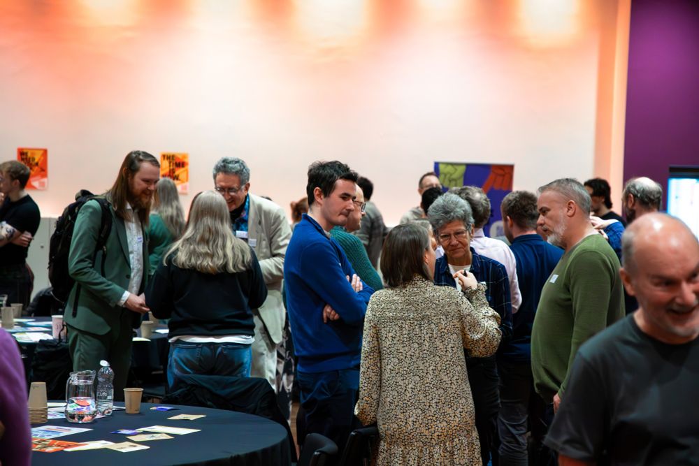 Groups of people are stood talking to one another.