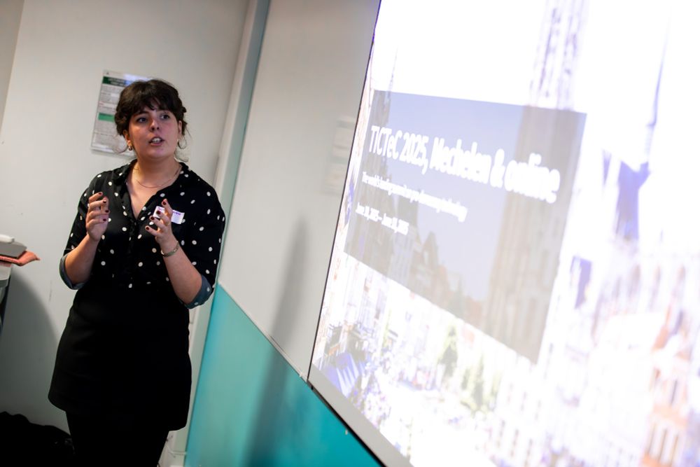 A person talks animatedly before a projected presentation.