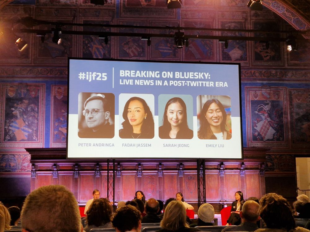 A projected screen displaying "Breaking on Bluesky" in an old Italian building with painted murals across the walls and ceiling.