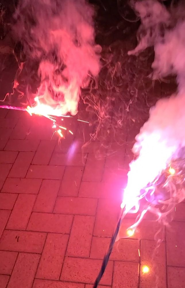 手持ち花火を光らせているところ。赤い火花が散っている