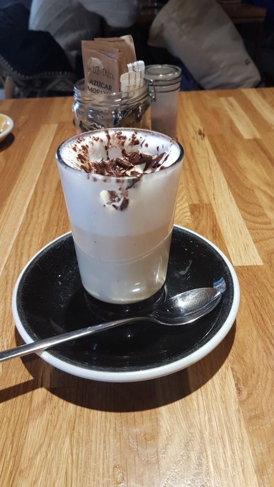 Glas voll Latte Macchiato auf einem Holztisch