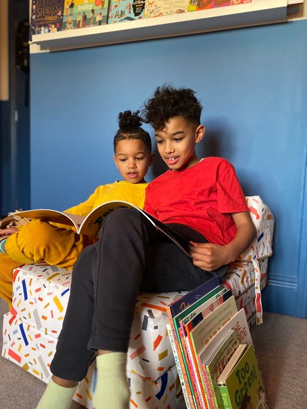 Image of two young children sharing books.