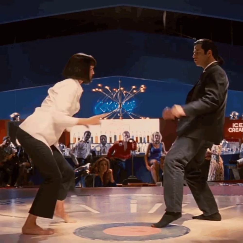 a man and a woman are dancing on a dance floor in front of a sign that says ice cream